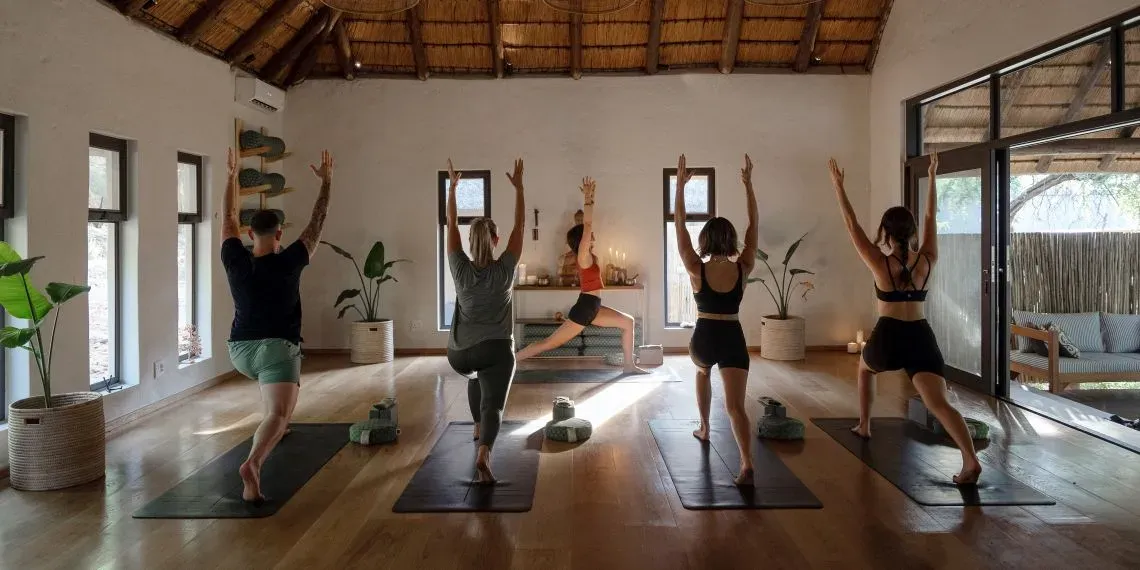 vijf mensen die binnen yoga beoefenen