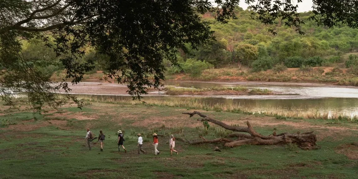 mensen lopen in de natuur langs de rivier
