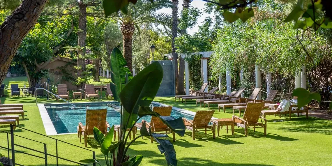 buitenzwembad met gras en groene palmbomen