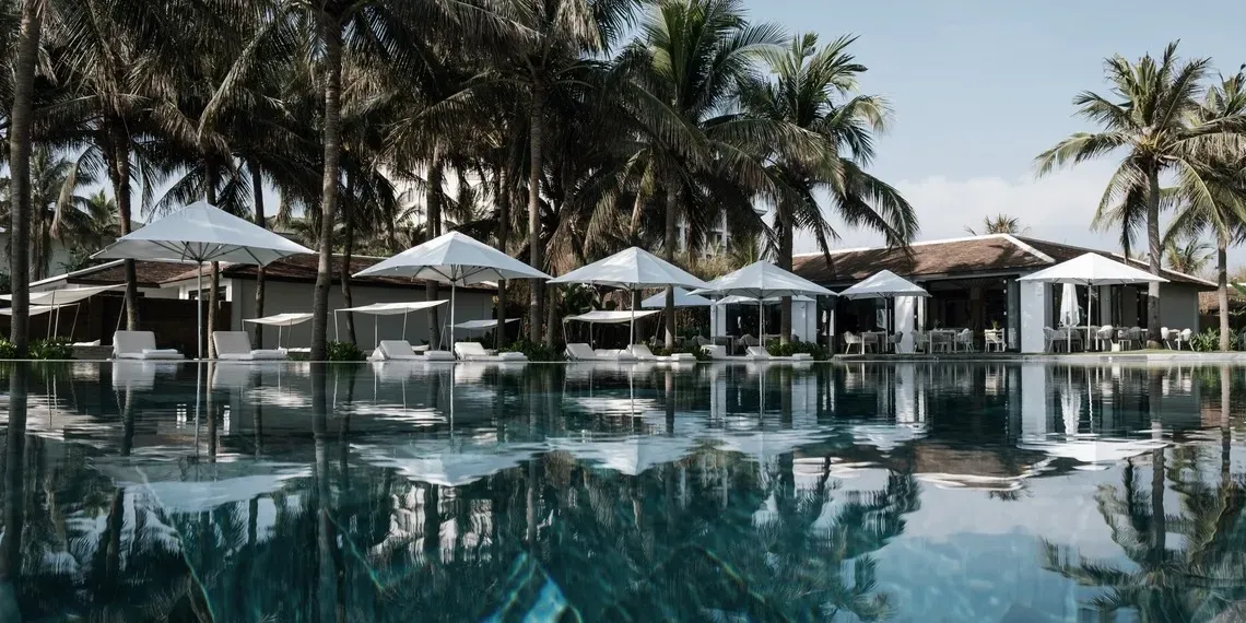 zwembad met parasol en lounge stoelen